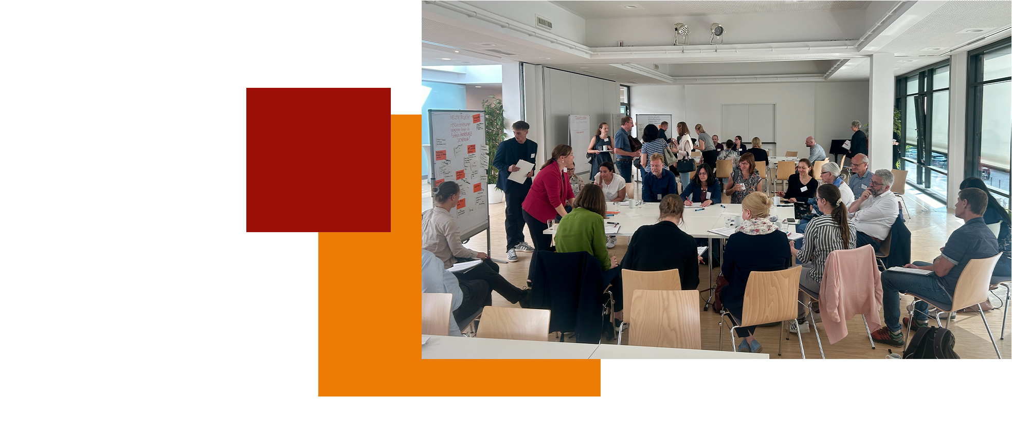 Menschen in einem hellen Raum diskutieren und machen Notizen bei einem Workshop oder Meeting.