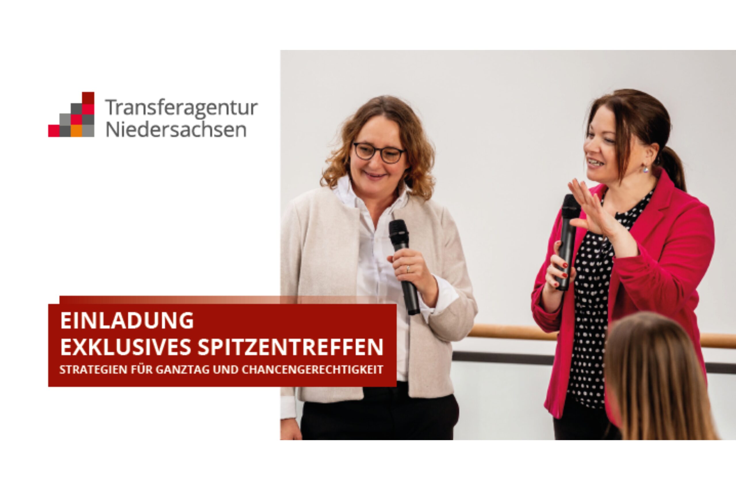 Zwei Frauen sprechen mit Mikrofonen bei einer Bildungskonferenz, eine trägt einen roten Blazer.